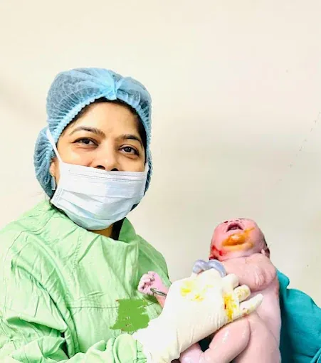 Dr. Bhavya Rathore holding a newborn after delivery