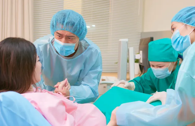 Delivery room with obstetric team supporting a mother during labour